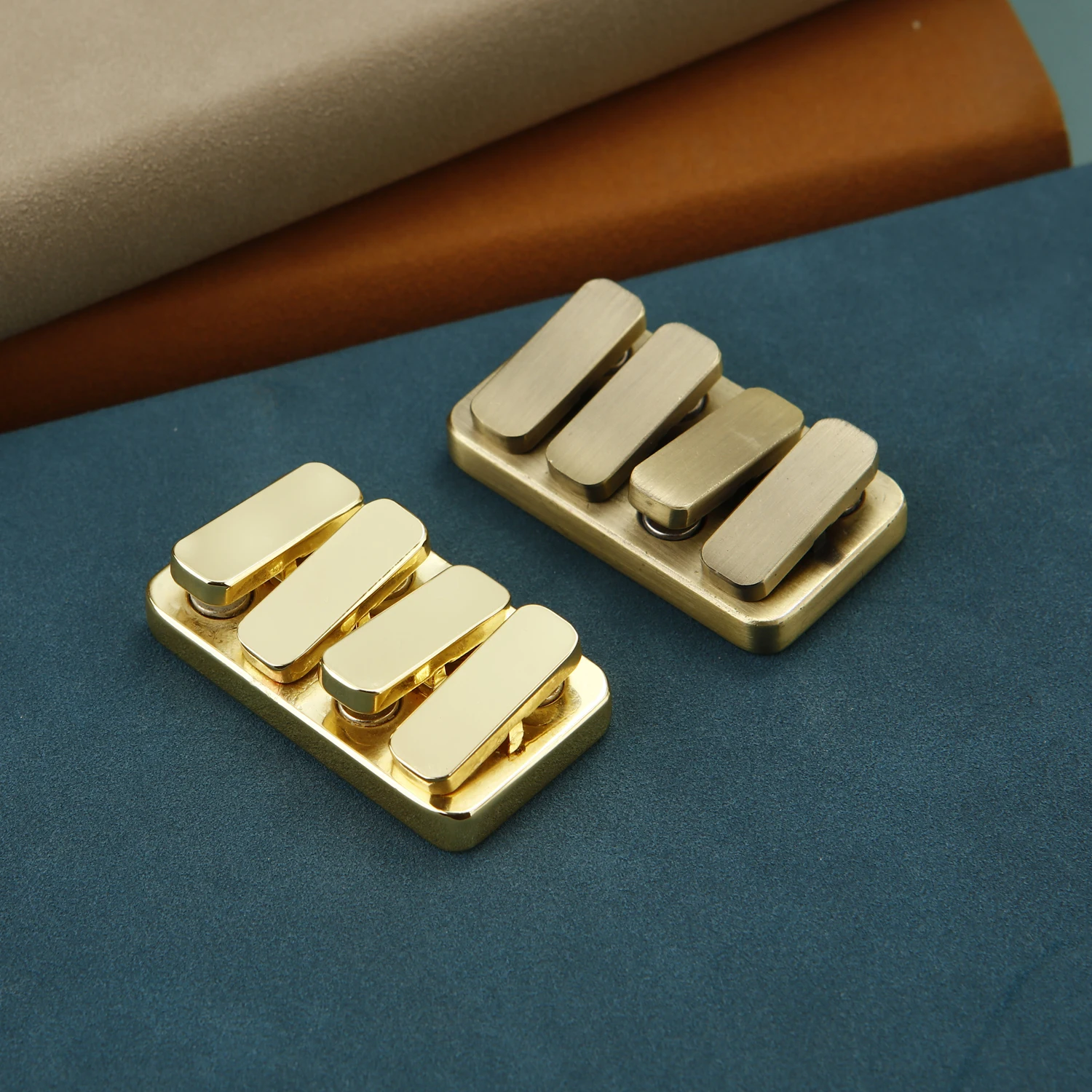 Two solid brass magnetic sliders on a desk